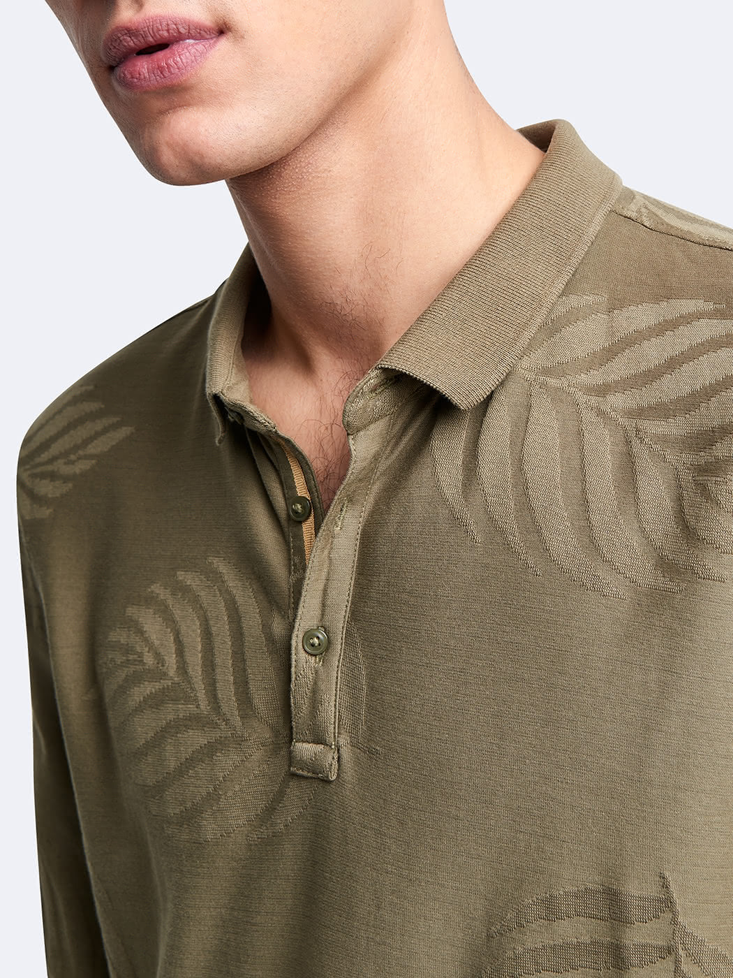 Zoom sur la boutonnière du polo Devred kaki à manches longues avec détails feuilles adapté par Adapt & Joy, illustrant le système de fermeture facilitant l’habillage des personnes en situation de handicap ou seniors.