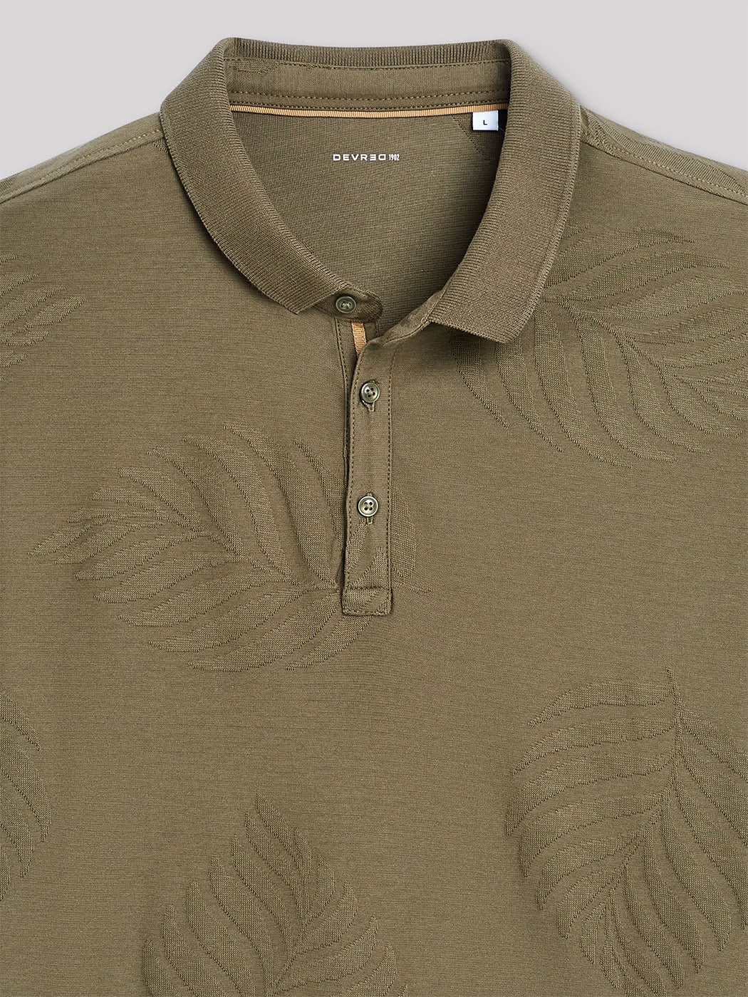 Zoom sur le polo Devred kaki à manches longues avec détails feuilles adapté par Adapt & Joy, montrant la finition et l’ouverture facilitant l’habillage pour les personnes en situation de handicap ou seniors.