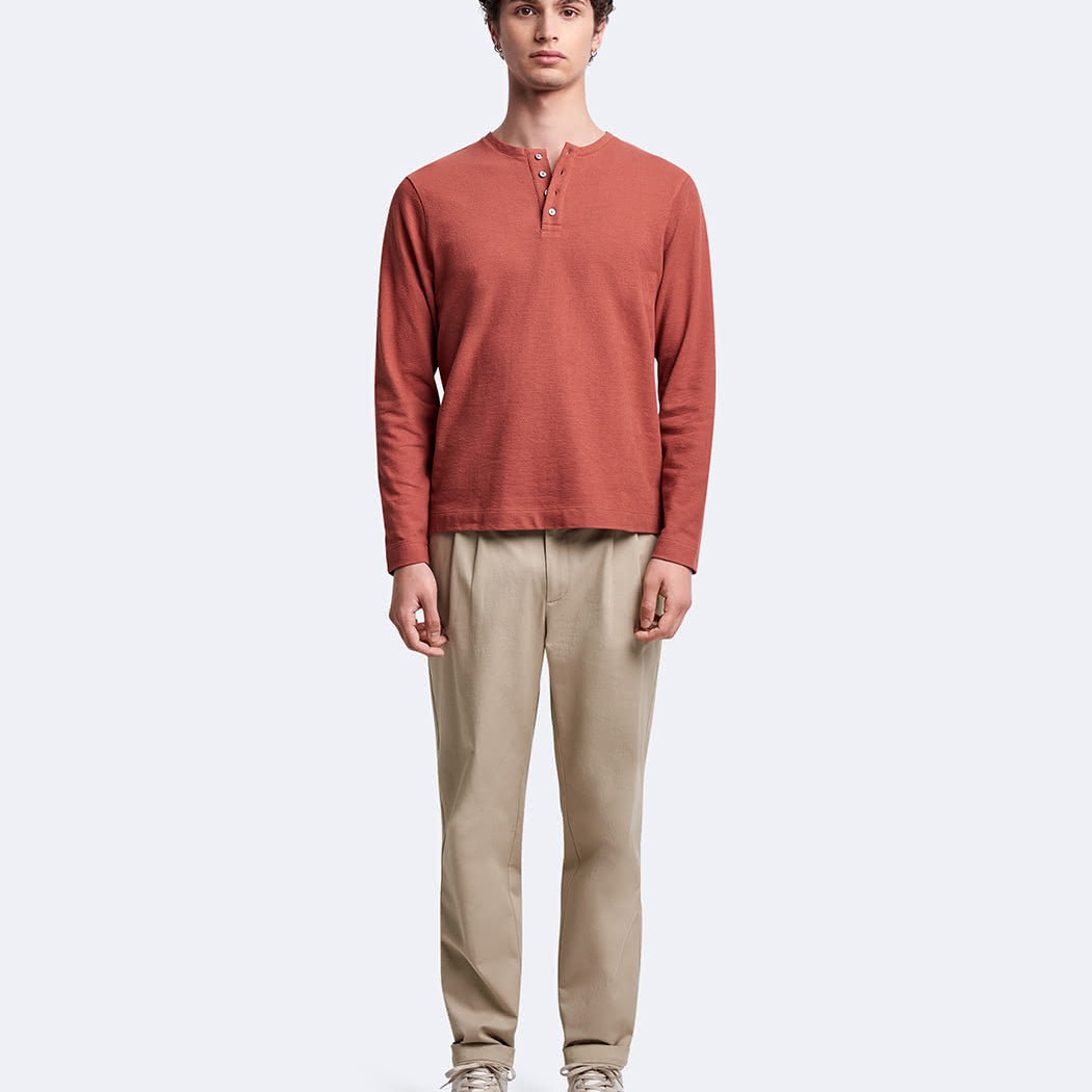 Vue en pied du mannequin portant le t-shirt Devred orange à manches longues et col tunisien Devred adapté par Adapt & Joy, conçu pour allier style, confort et autonomie lors de l’habillage des personnes en situation de handicap ou seniors