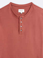 Zoom sur le t-shirt orange à manches longues et col tunisien Devred adapté par Adapt & Joy, avec ouverture facilitée pour l’habillage des personnes en situation de handicap ou seniors